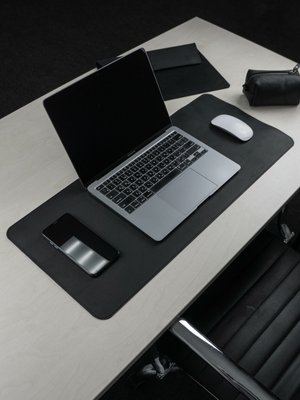 Кожаный ковер на столе под черный ноутбук.